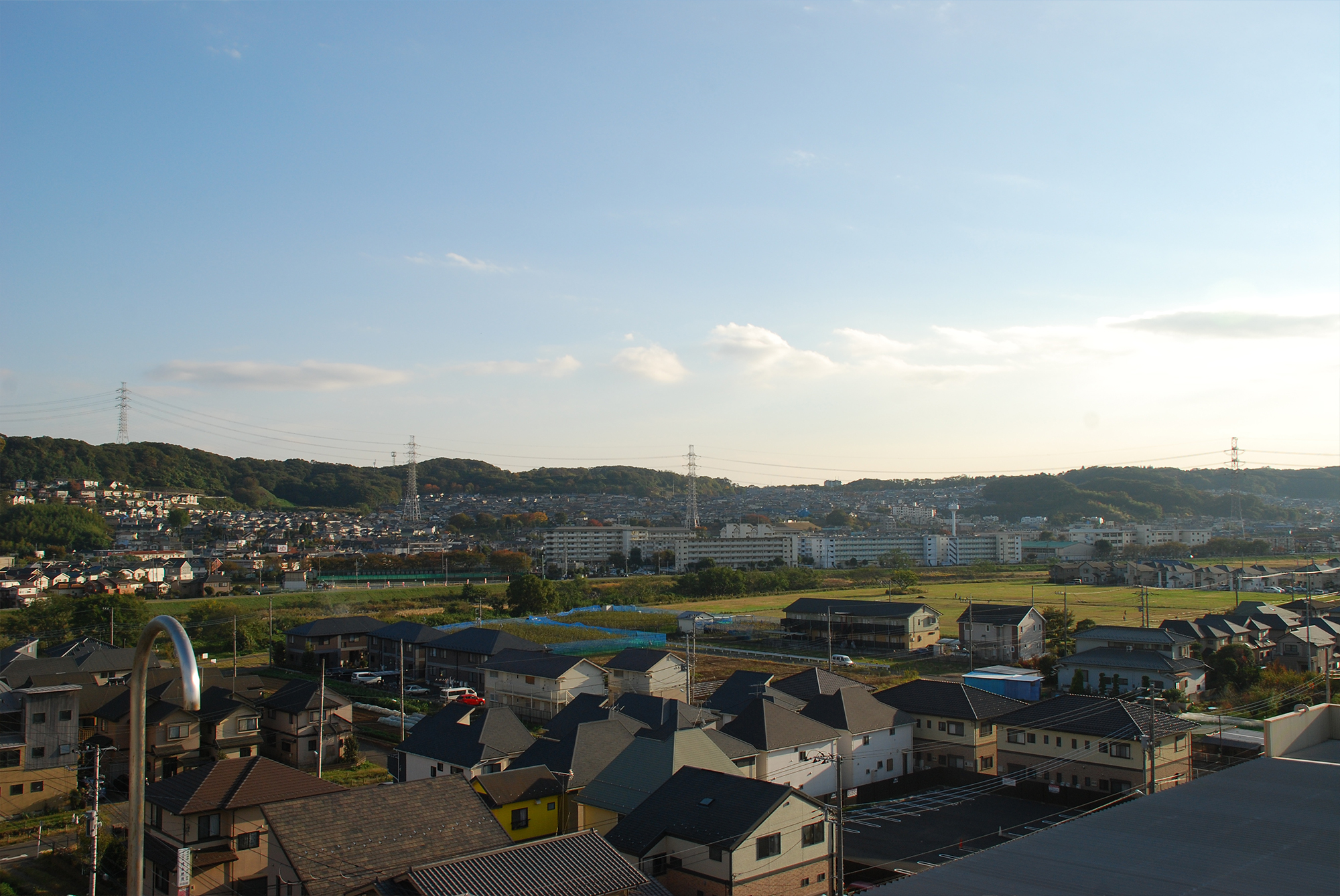 施設周辺の町並みと田園風景を映した眺望。丘陵地に広がる住宅地と農地。